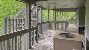 A covered outdoor deck with wooden railings and a central air conditioning unit. - Fairway Villa 1103 at Rumbling Bald (Lake Lure)