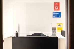 A reception desk with a clear view of a sign indicating 'Super 9.0' and 'Private Transfers'.