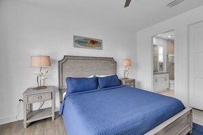 A bedroom with a bed, nightstands, and a mirror.