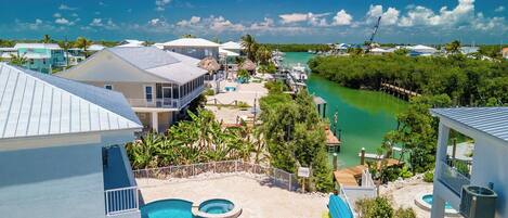 Um resort com piscina, um píer e vista para a água.