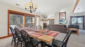 A spacious dining area with a wooden table, black chairs, and a chandelier. - Silver Cliff 2BD - 2BA, Steps to PC Skiing and Old Town (Park City)