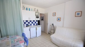 A compact room with a kitchenette, a dining table, a sofa, and a bed. - Sea view cabin studio i (Saint-Cyprien)
