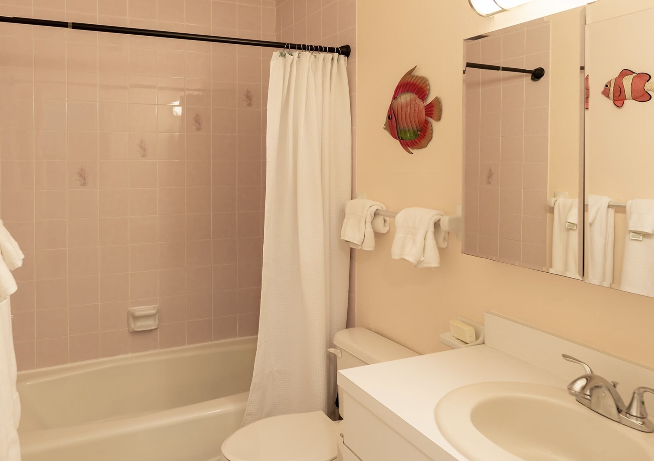 Un baño con bañera, inodoro, lavamanos y cortina de ducha.