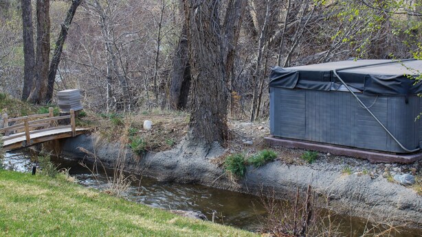 A covered outdoor structure near a stream with a wooden bridge. - Romantic Private Space for Couple's Getaway w/Hot Tub (Buena Vista)