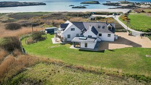 A large white house with a spacious yard, a swimming pool, and a view of the sea and hills. - Glan Towyn (Holyhead)