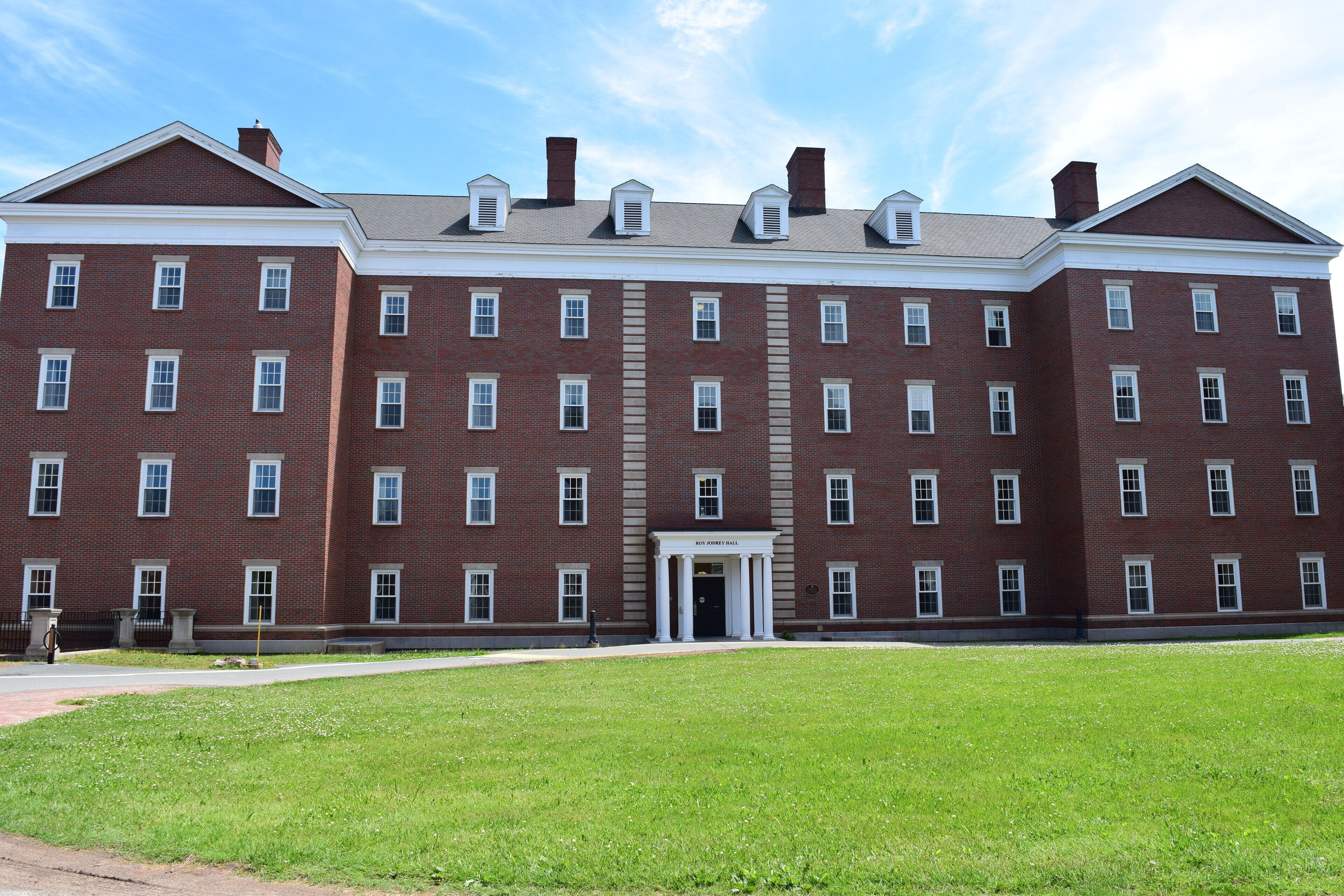 A large brick building with a symmetrical facade, multiple windows, and a central entrance labeled "Baker Hall".