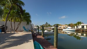 A marina with a wooden dock, boats, and a clear blue sky. - Nice and cozy home is just a short walk to the beach and pool! (Key Colony Beach)