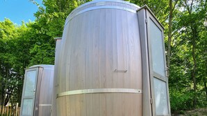 A cylindrical wooden structure with a sliding door, a small platform, and a window. - Haus der Schmetterlinge (Uslar)