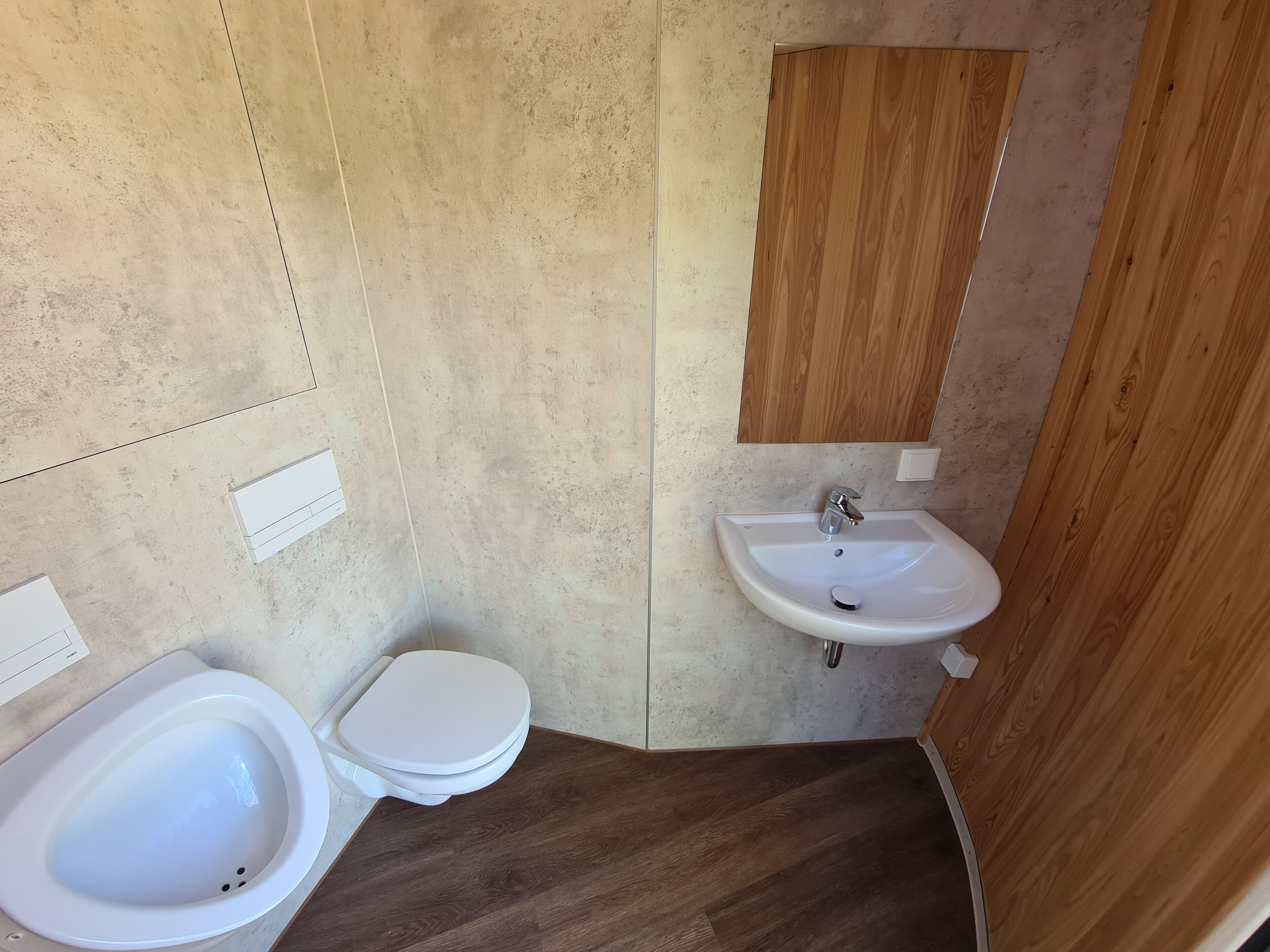 A bathroom with a white toilet, bidet, and sink.