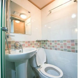 A bathroom with a sink, toilet, and mirror. - Isak Minitel (Seoul)