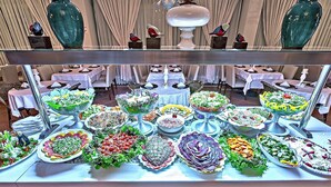 Una mesa de buffet con diversos platos y un florero decorativo.