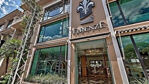 Entrada de hotel con un gran letrero que dice "FIRENZE" y un emblema decorativo encima.