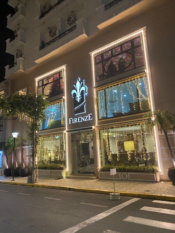 A building with a prominent 'FIRENZE' sign, large windows, and decorative lights.