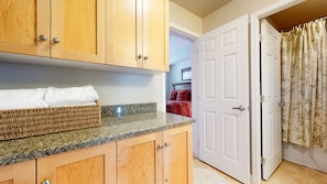 Cozy retreat with a kitchenette and bedroom, featuring a bed with a bold bedspread.