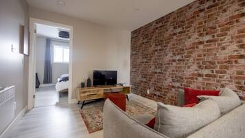 Suite avec chambre fermee | Área de sala de estar | Televisión de pantalla plana