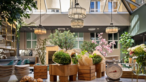 Un hall d’hôtel au design moderne, avec une grande fenêtre, un lustre et une statue.
