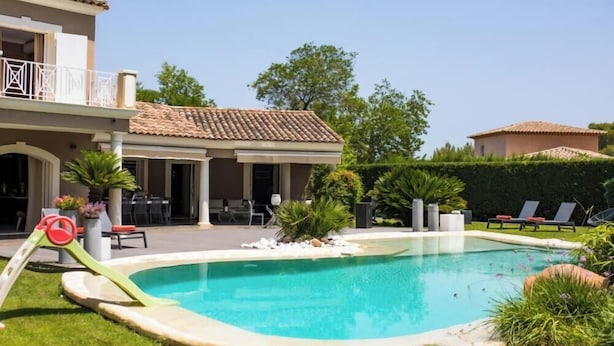 Una casa de dos pisos amb piscina, mobiliari exterior i zona de terrassa.