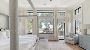 A spacious bedroom with a large bed, a sofa, a cat tree, and a dresser. - New Build in desirable Ocean Park community (Kiawah Island)