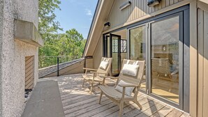 A wooden deck with wicker chairs and a glass door leading to a room. - New Build in desirable Ocean Park community (Kiawah Island)