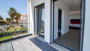 A modern apartment with a balcony, large sliding glass doors, and a view of the surrounding neighborhood. - Dalma- Villa da Ourada (Albufeira)