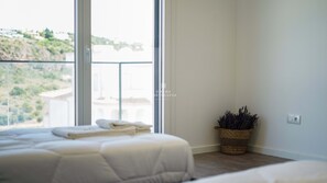 Enjoy a peaceful retreat with a hillside view from this serene bedroom featuring a comfortable bed and a soothing atmosphere.