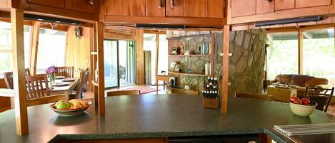 A kitchen with wooden cabinets, a dishwasher, and a stone wall.