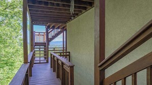 Eine Holztreppe führt zu einer Terrasse mit Blick auf die Landschaft.