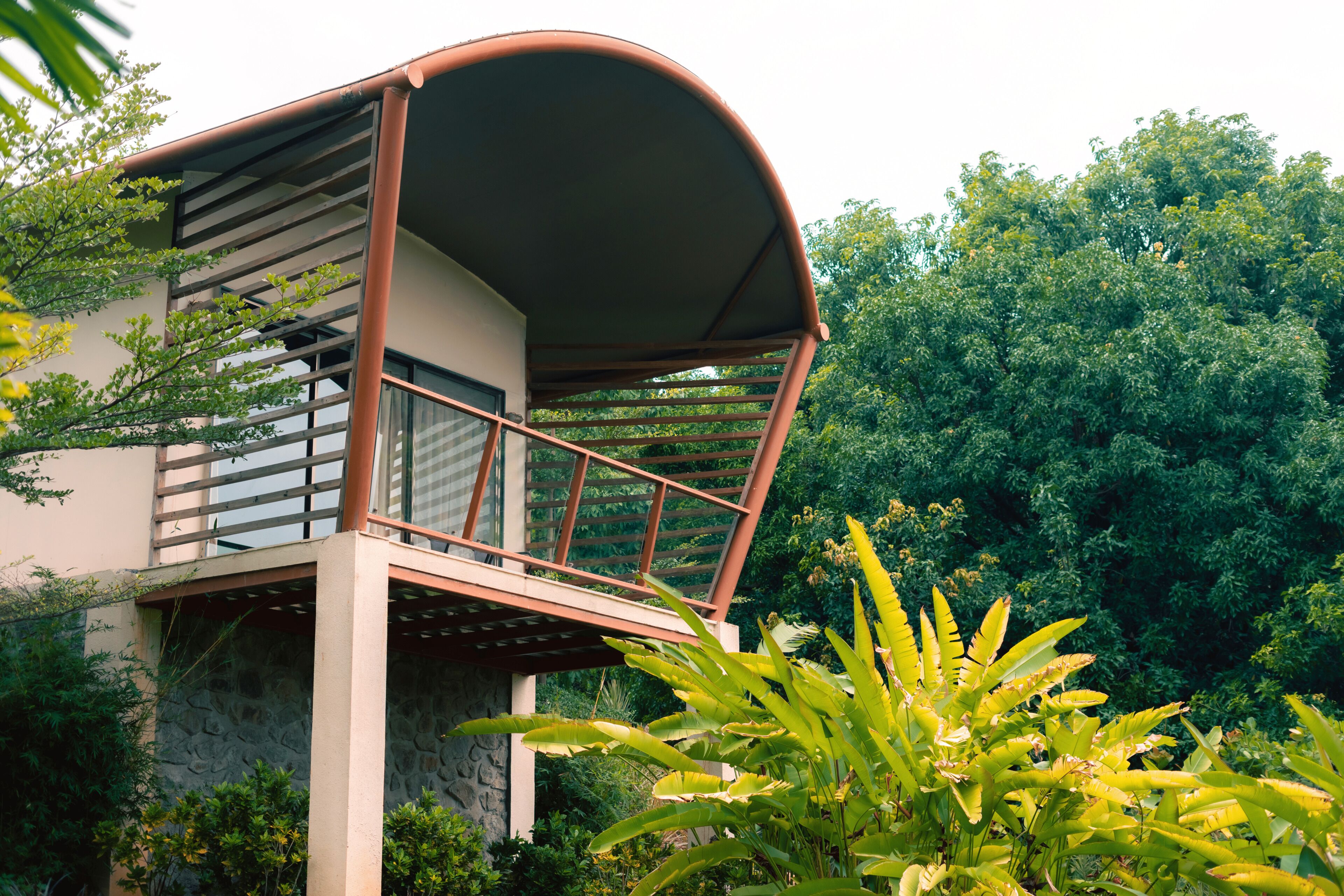 A modern building with a curved roof and a balcony.
