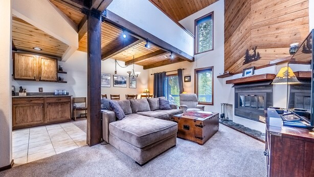 Un amplio espacio de estar con un sofá modular grande, una mesa de comedor de madera y una chimenea.