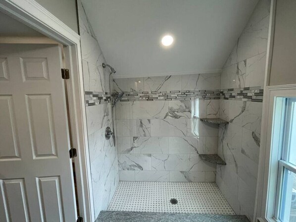 A walk-in shower with marble walls and a tiled floor. - 33 W. Moler (Upstairs ) · Modern Chic in German Village & Merion Village Area (Columbus)