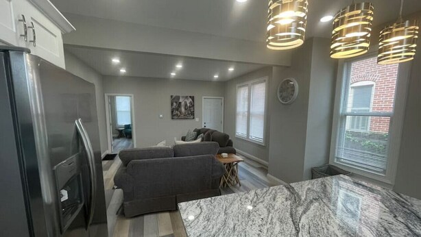 A modern kitchen with a marble countertop, built-in appliances, and pendant lighting. - Modern and Chic in German & Merion Village Area (Columbus)