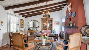A traditional living room with wooden furniture, a chandelier, and a fireplace. - 3BR w/ Pool + Outdoor Fireplace | Near Downtown (Palm Springs)