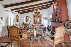 Un salon traditionnel avec des meubles en bois, un lustre et une cheminée.