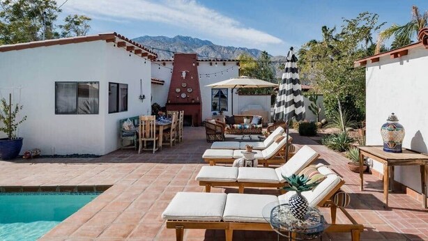 A poolside area with lounge chairs, a dining table, and a barbecue grill. - 3BR w/ Pool + Outdoor Fireplace | Near Downtown (Palm Springs)