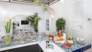 Un buffet de petit-déjeuner proposant une variété de plats et de boissons, une cuisine moderne en arrière-plan et une porte blanche.