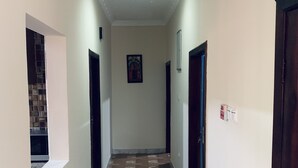 A hallway with patterned flooring, white walls, and doors on both sides.