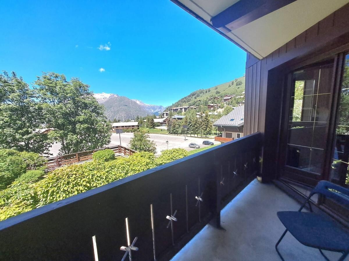 Ein Balkon mit Blick auf eine gebirgige Landschaft, ein Stuhl und ein Fenster.