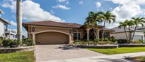 A residential house with a garage, a driveway, and a well-maintained lawn.