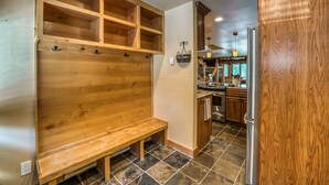 Una cocina con armarios de madera, un banco empotrado y un colgador de luz.