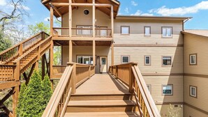 A multi-story wooden building with a central staircase leading to a balcony. - Relaxed Retreat with Premiere Location and Views, Only 6 Steps to Get In, Garage (Whittier)