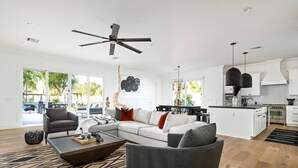 Amplia sala de estar con sofá, mesa de centro y ventilador de techo.
