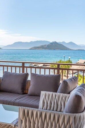 A balcony with a sofa and cushions, overlooking a body of water and distant mountains. - Alkis House Astonishing Sea View deluxe appartment (AEGINA)