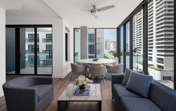 Enjoy meals and social gatherings around the central round table, surrounded by comfortable seating and expansive city views.