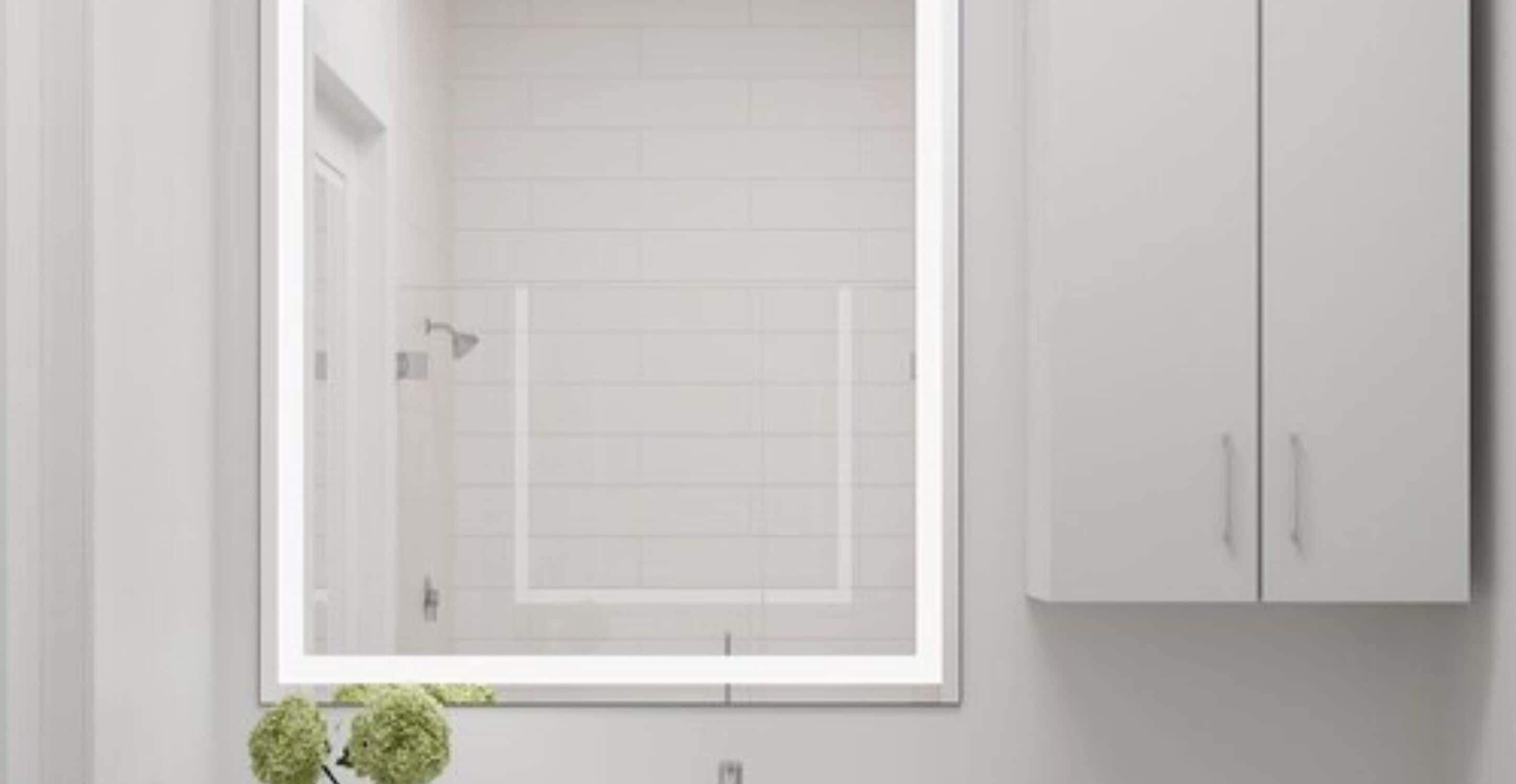A modern bathroom with a large mirror, white tiles, and a cabinet.