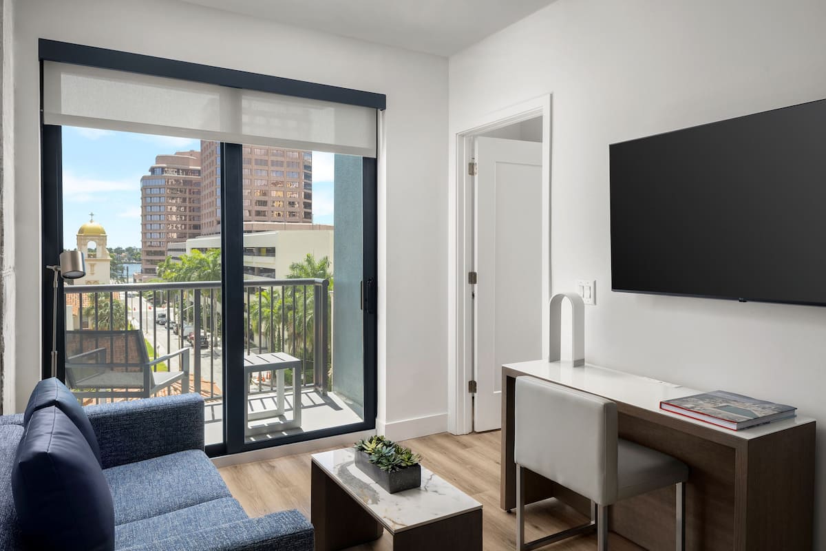 Een modern appartement met balkon, bureau en een comfortabele zithoek.