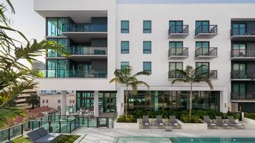 Un hôtel moderne doté d’une piscine sur le toit, de nombreux balcons et d’une végétation luxuriante.