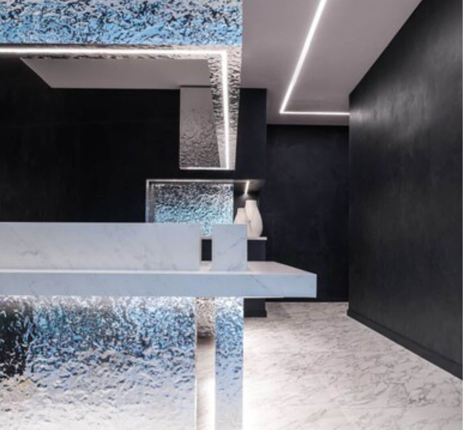 A modern interior with a marble countertop, a dark wall, and a ceiling light fixture.