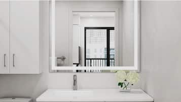 A modern bathroom with a white vanity, a large mirror, and a vase of white flowers.
