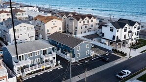 Un área residencial costera con casas a lo largo de la calle, una señal de parada y un coche en la carretera.