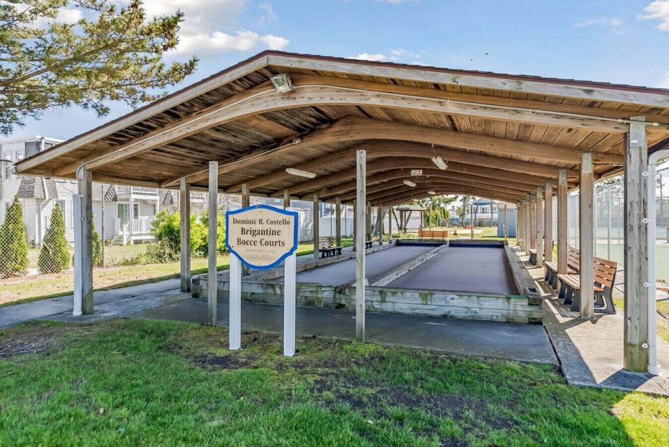 A covered outdoor area with a sign for Dominic R. Costello Brigantine Bocce Courts.